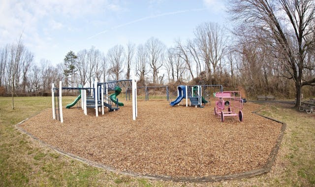 Playground with slides, swings, and a pink toy car ride