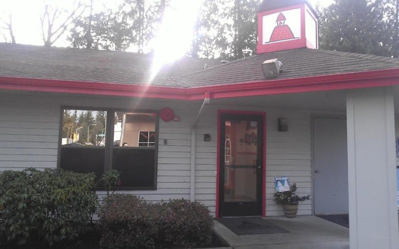 Building exterior with a red roof, windows, and an entrance