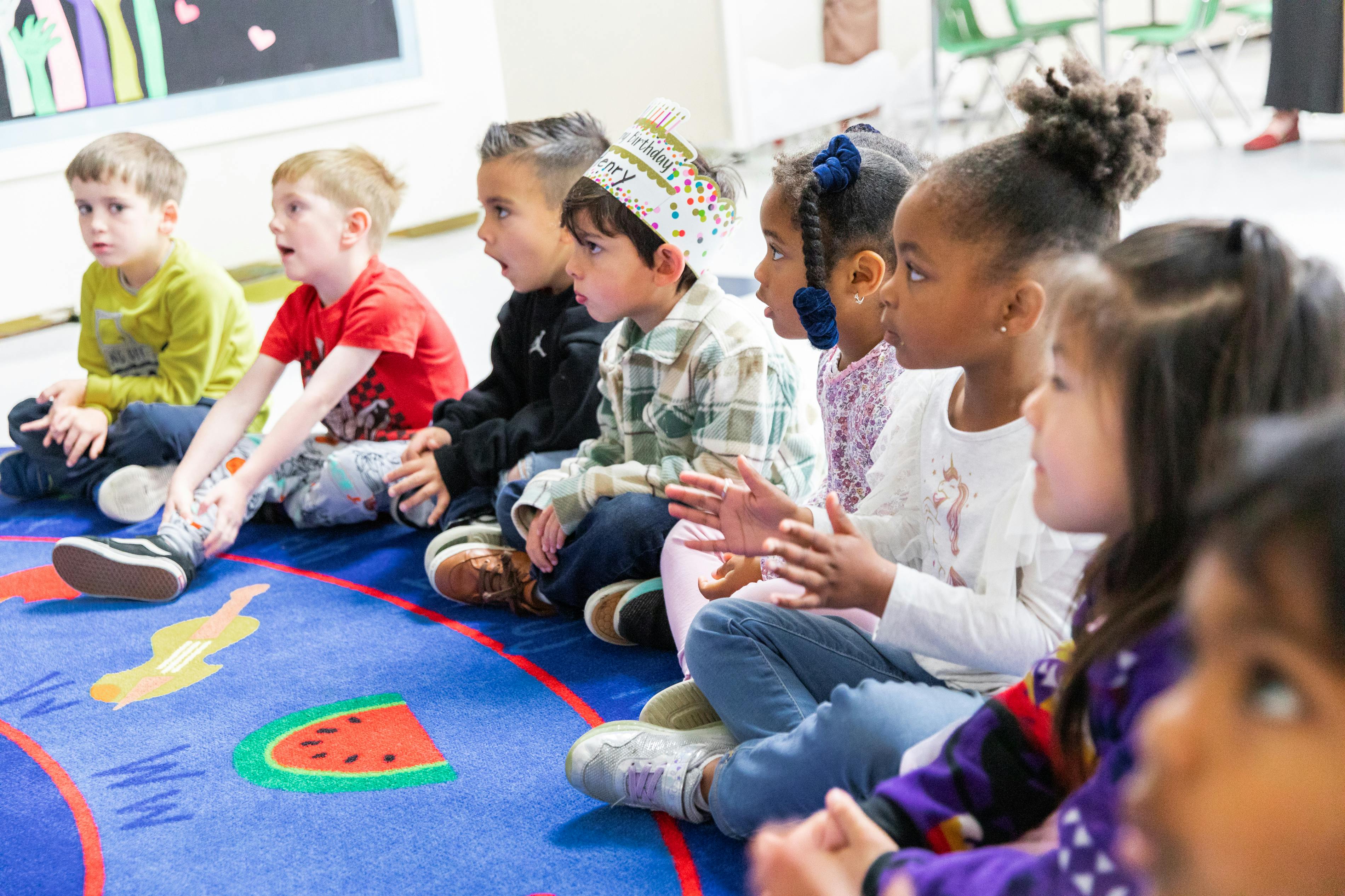Children sitting on a rug in a classroom