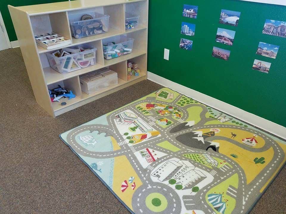 Playroom with a toy storage shelf and a road map play rug