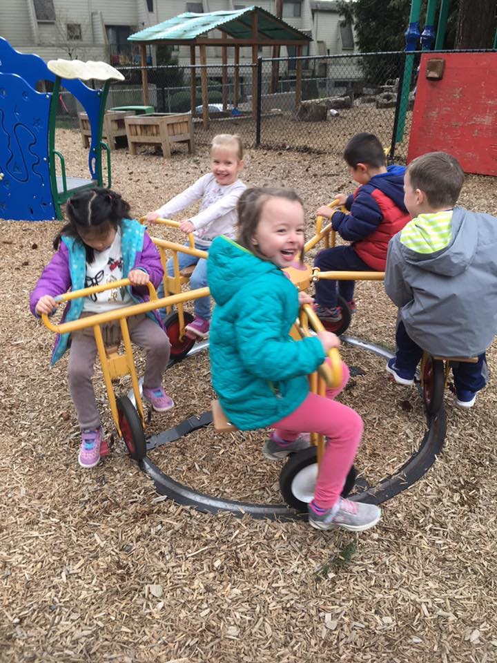 Children playing on a multi-person tricycle in a playground