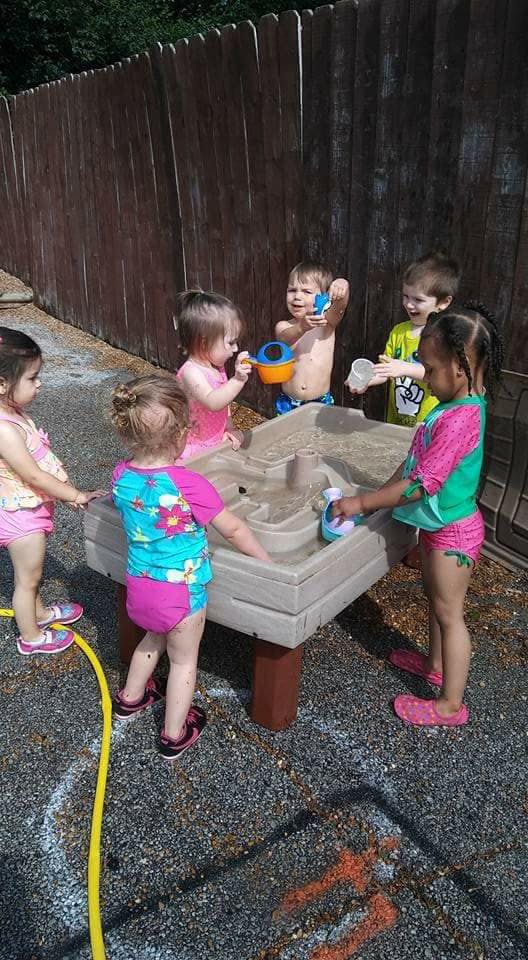 Children playing with a water table outdoors