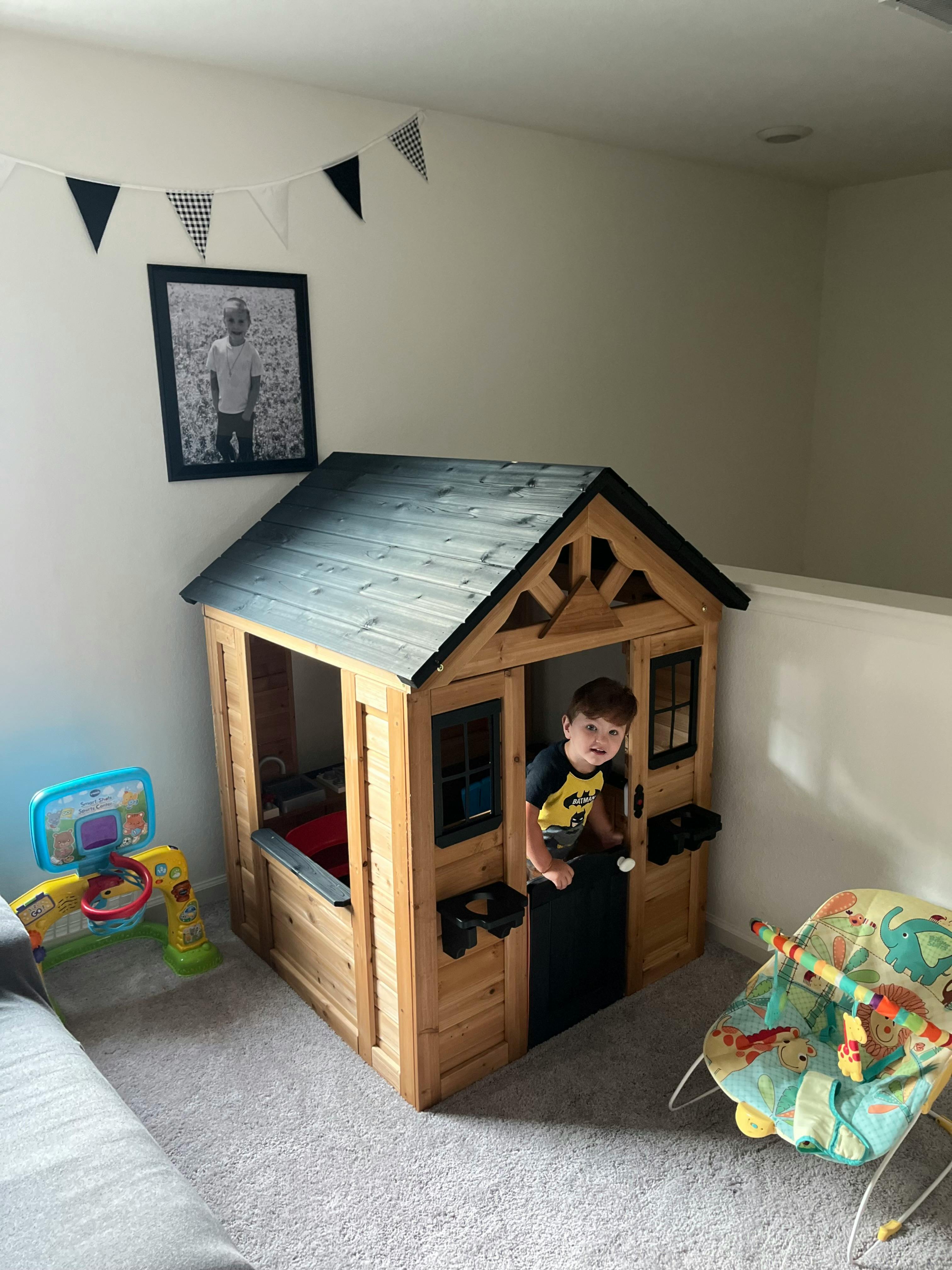 Child standing in a wooden playhouse