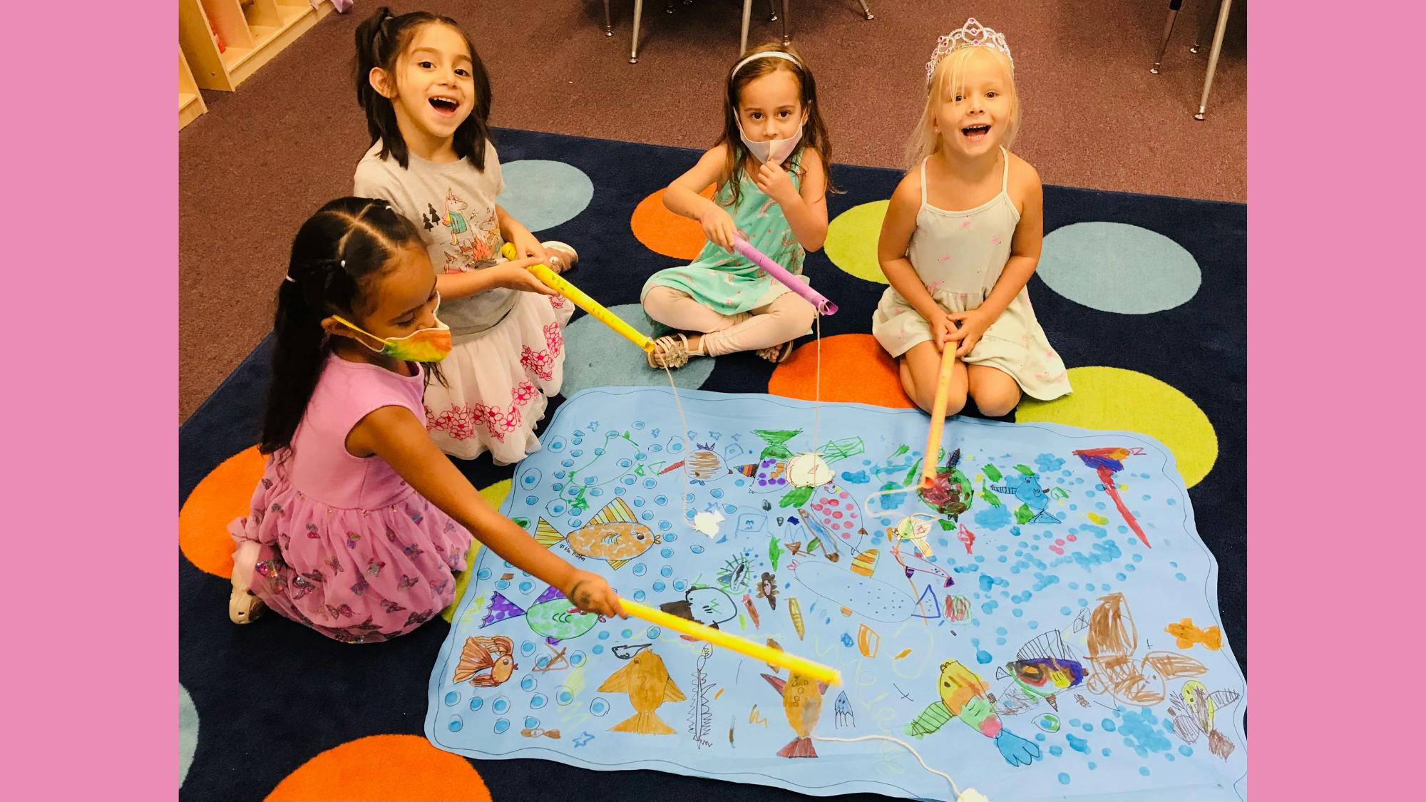 Four children playing a fishing game on a blue mat