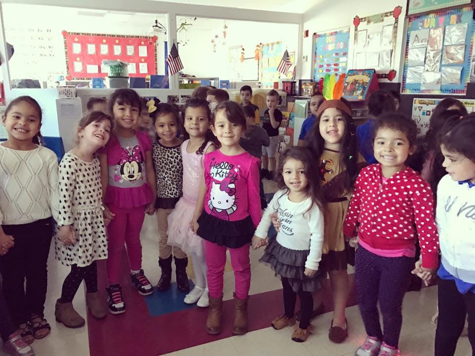 Group of children standing in a classroom
