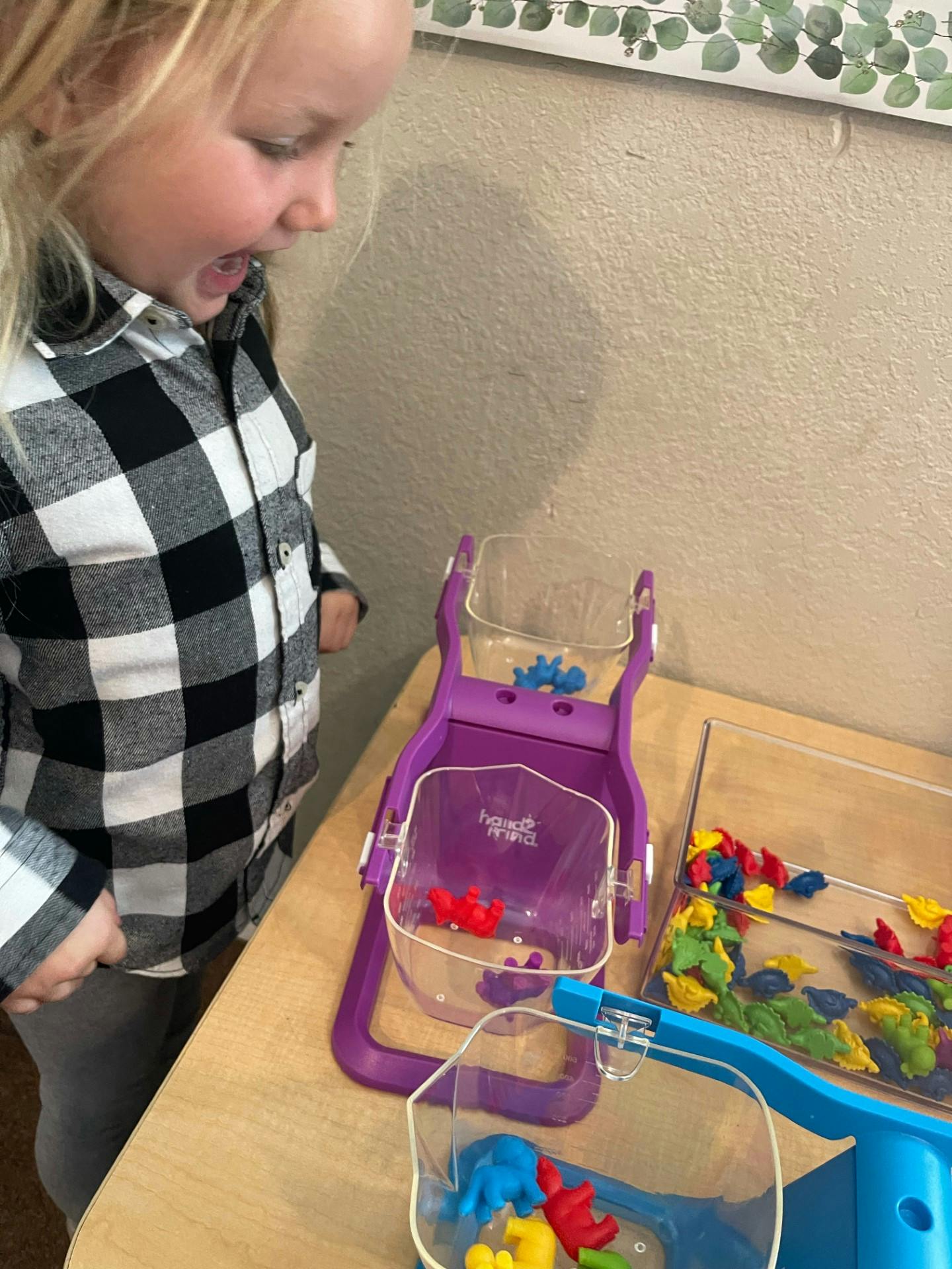 Child looking at colorful sorting toys on a table
