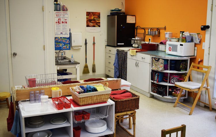 Play kitchen area with toy dishes and baskets