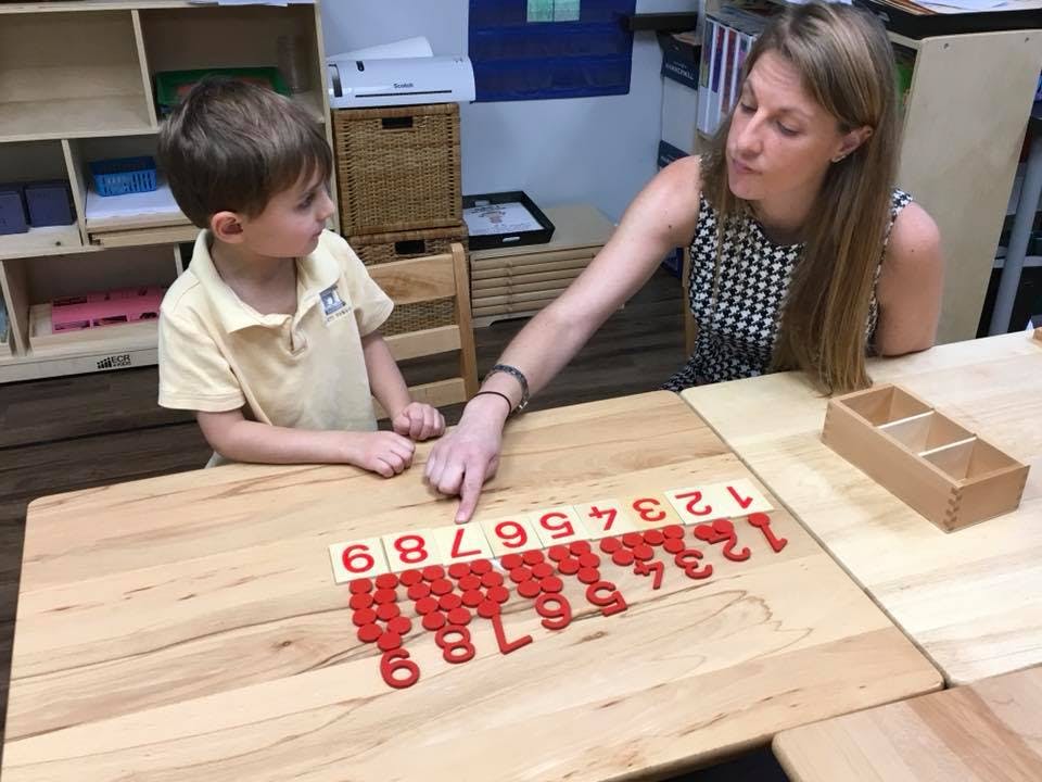 Adult and child learning numbers with red number tiles