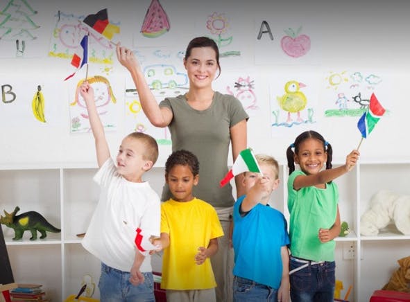 Adult and children holding small flags in a classroom