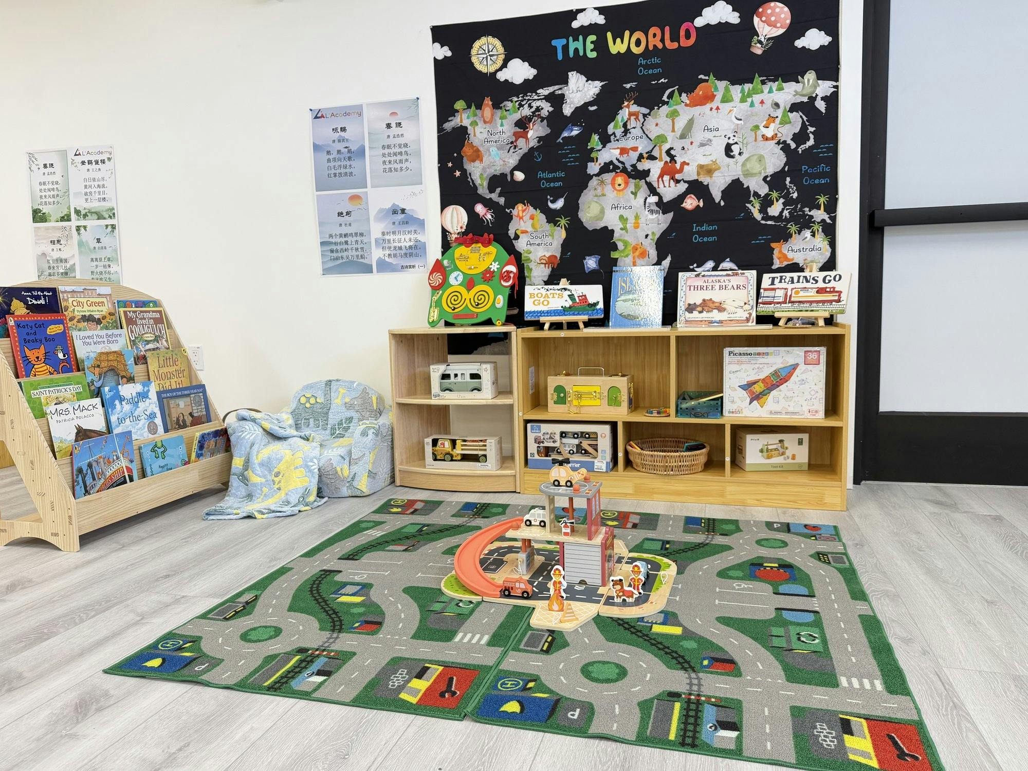 Children's play area with a world map, bookshelves, and a toy road rug