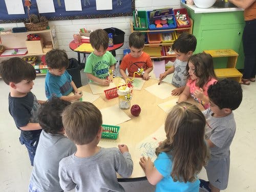Children gathered around a table in a classroom