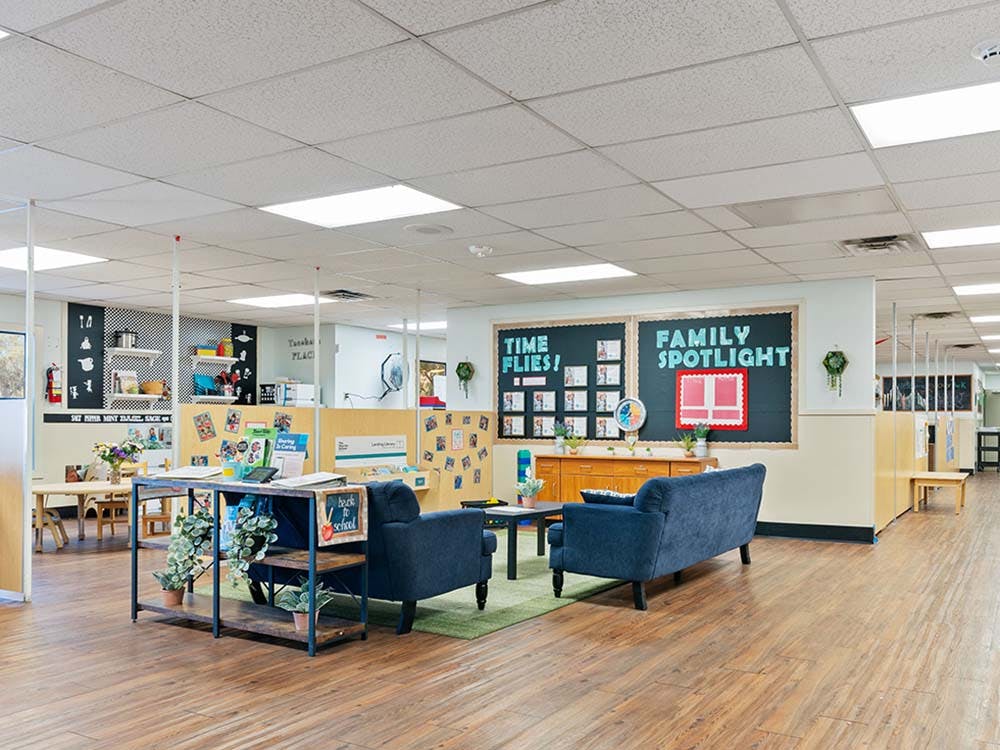 Classroom interior with couches, tables, and bulletin boards