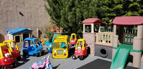 Children's play area with toy cars, a playhouse, and a slide
