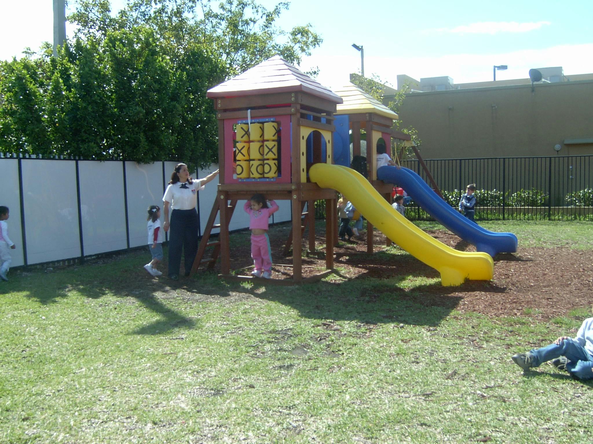 People and children on a playground with slides