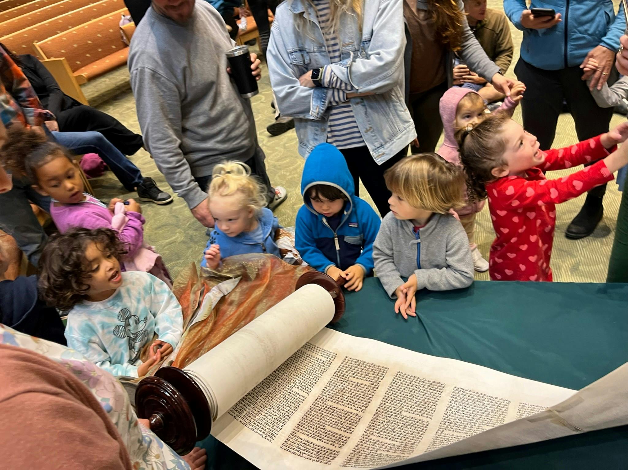 Children gathered around an open scroll