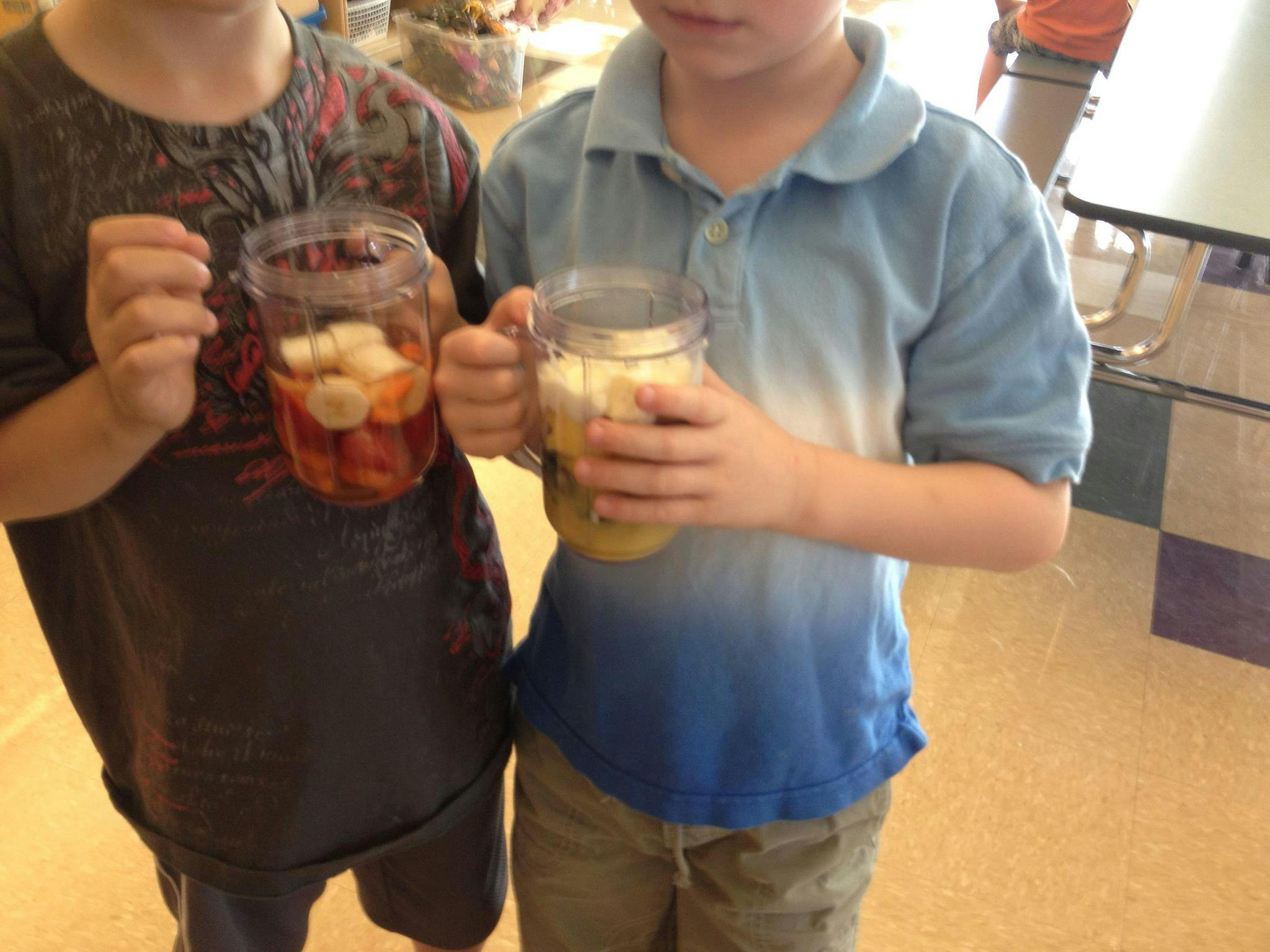 Two children holding jars with items inside