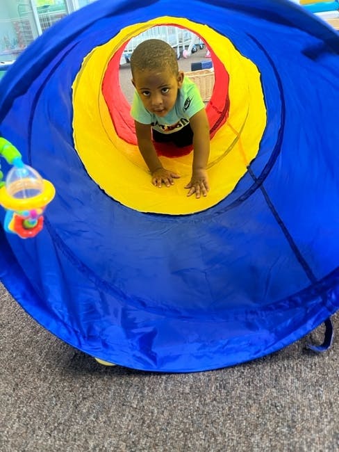 Child crawling through a play tunnel