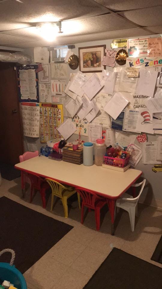 Classroom with a table and chairs, and papers on the wall