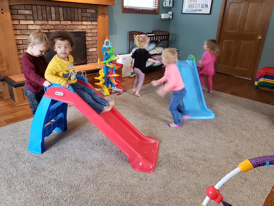 Children playing with slides and toys in a room