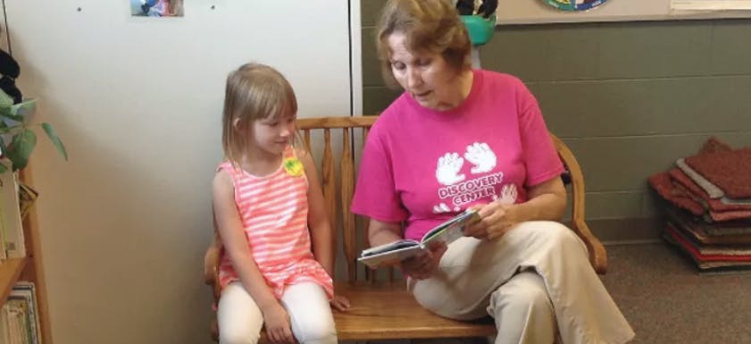 Person reading a book to a child