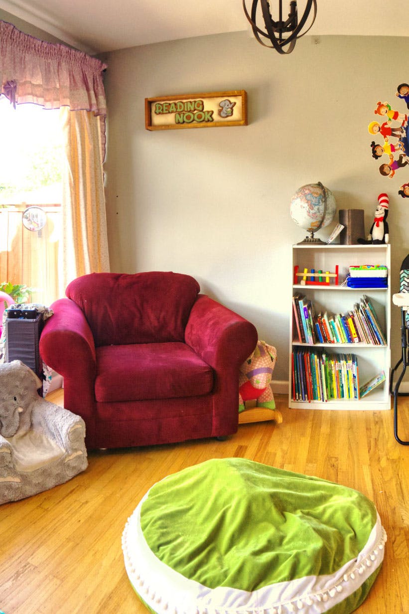 Reading nook with a red armchair, bookshelf, and a sign that says "READING NOOK"