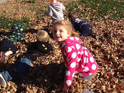 Children playing in a pile of autumn leaves