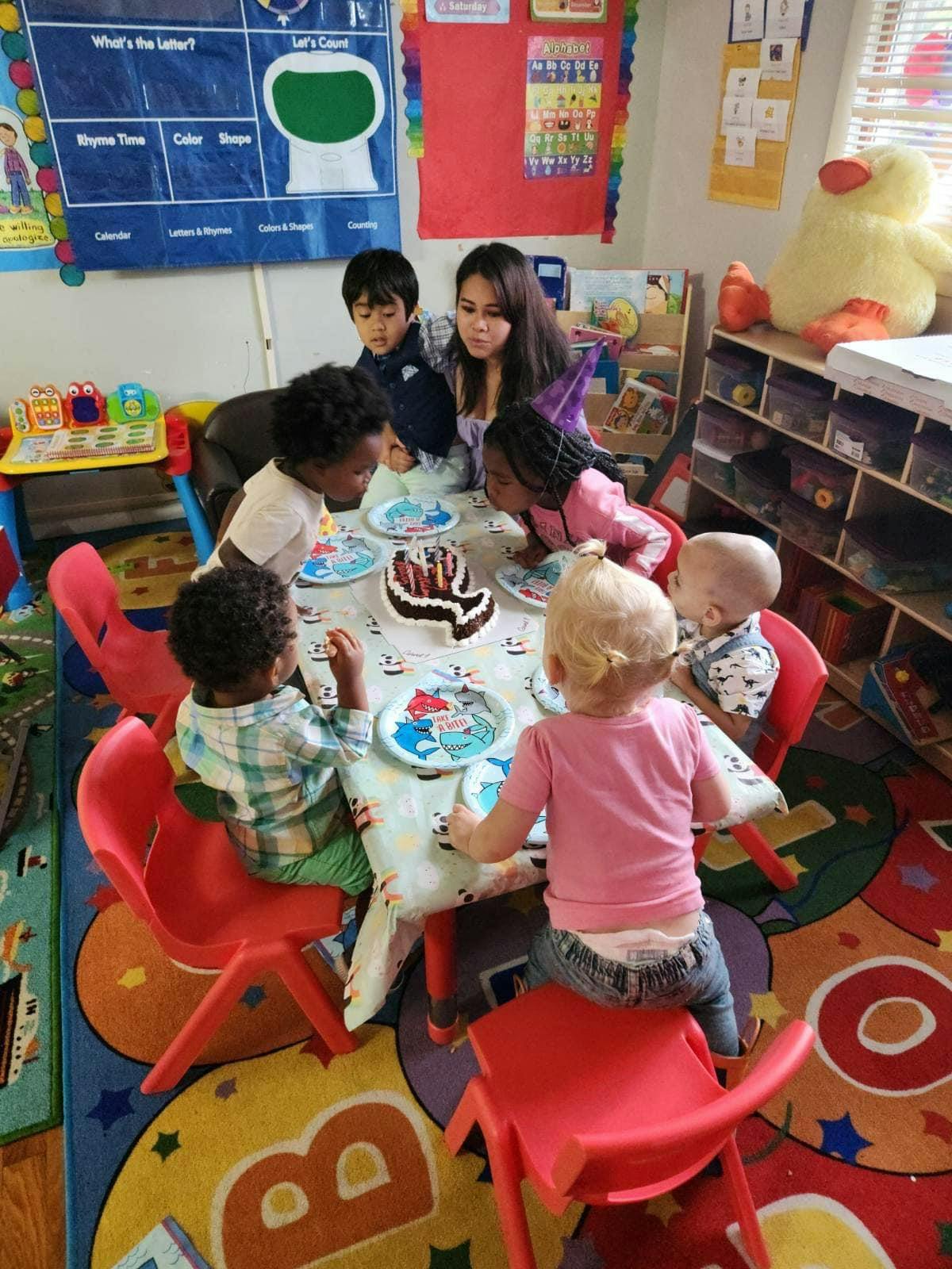 Adult and children gathered around a table with a cake