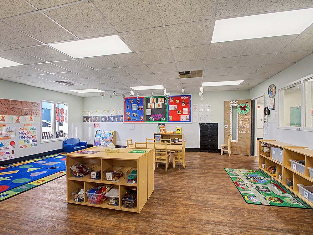 Empty colorful preschool classroom with small tables and chairs