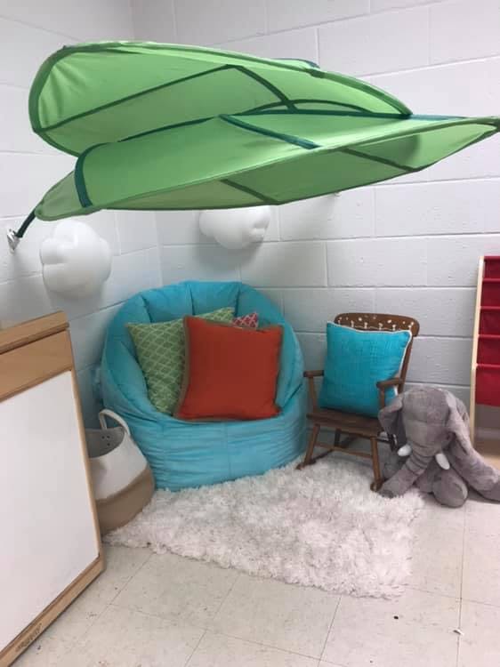 Green leaf-shaped canopy over a blue beanbag chair and small wooden chair