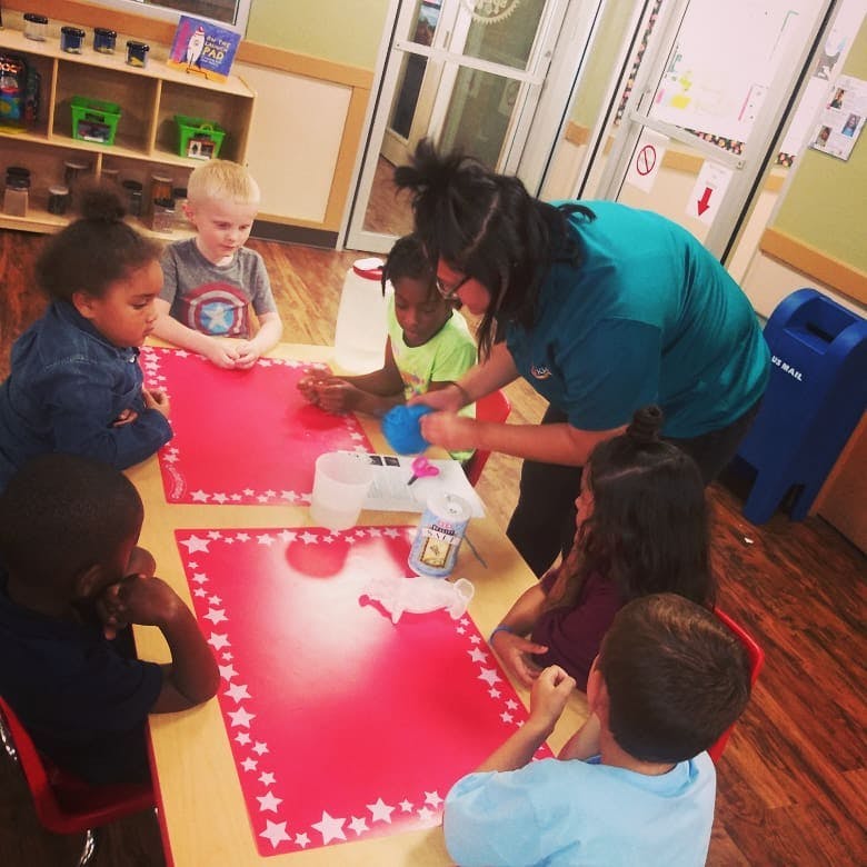 Adult and children at a table with red placemats