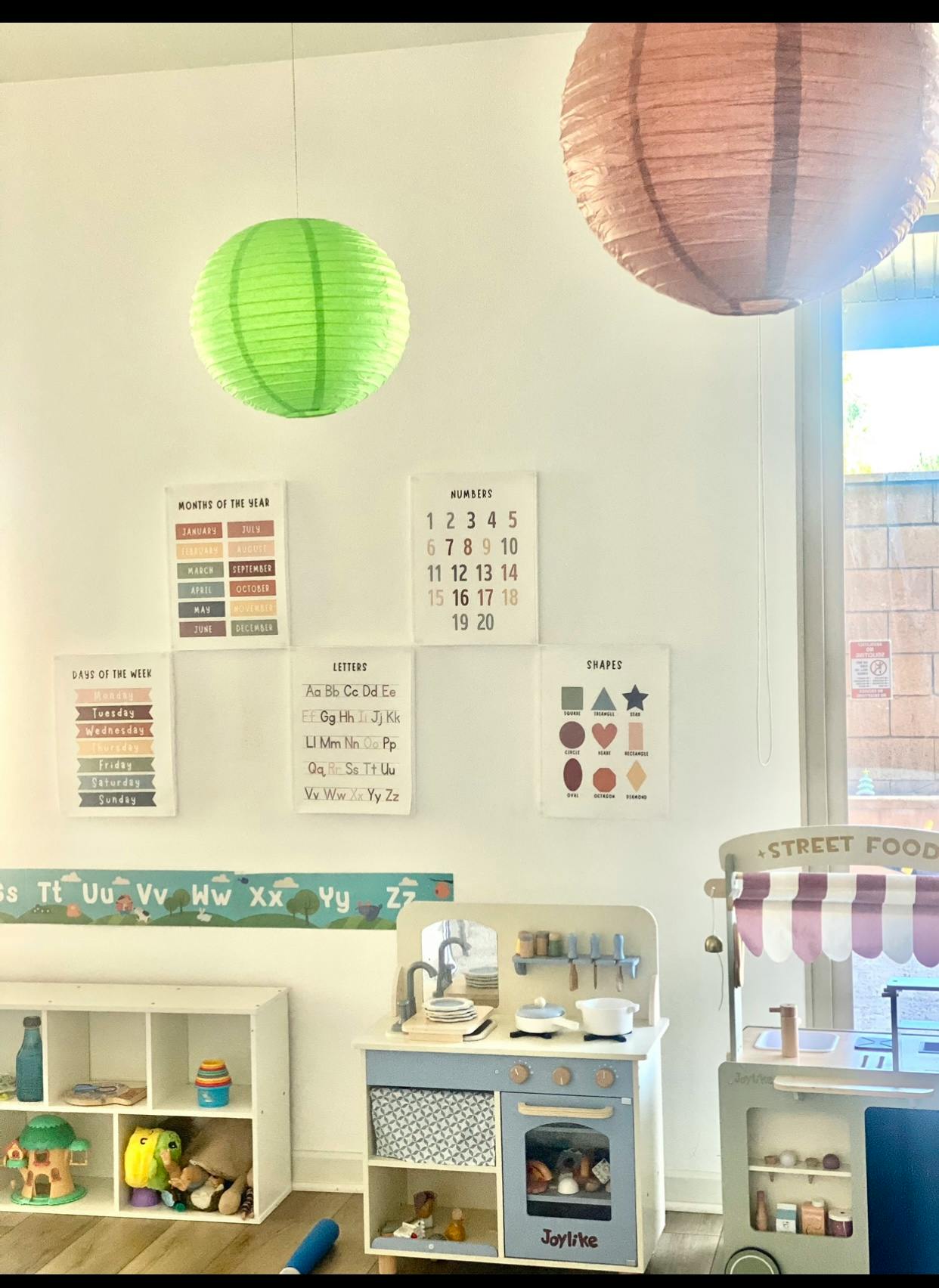 Playroom with educational posters, toy kitchen, and toy food cart