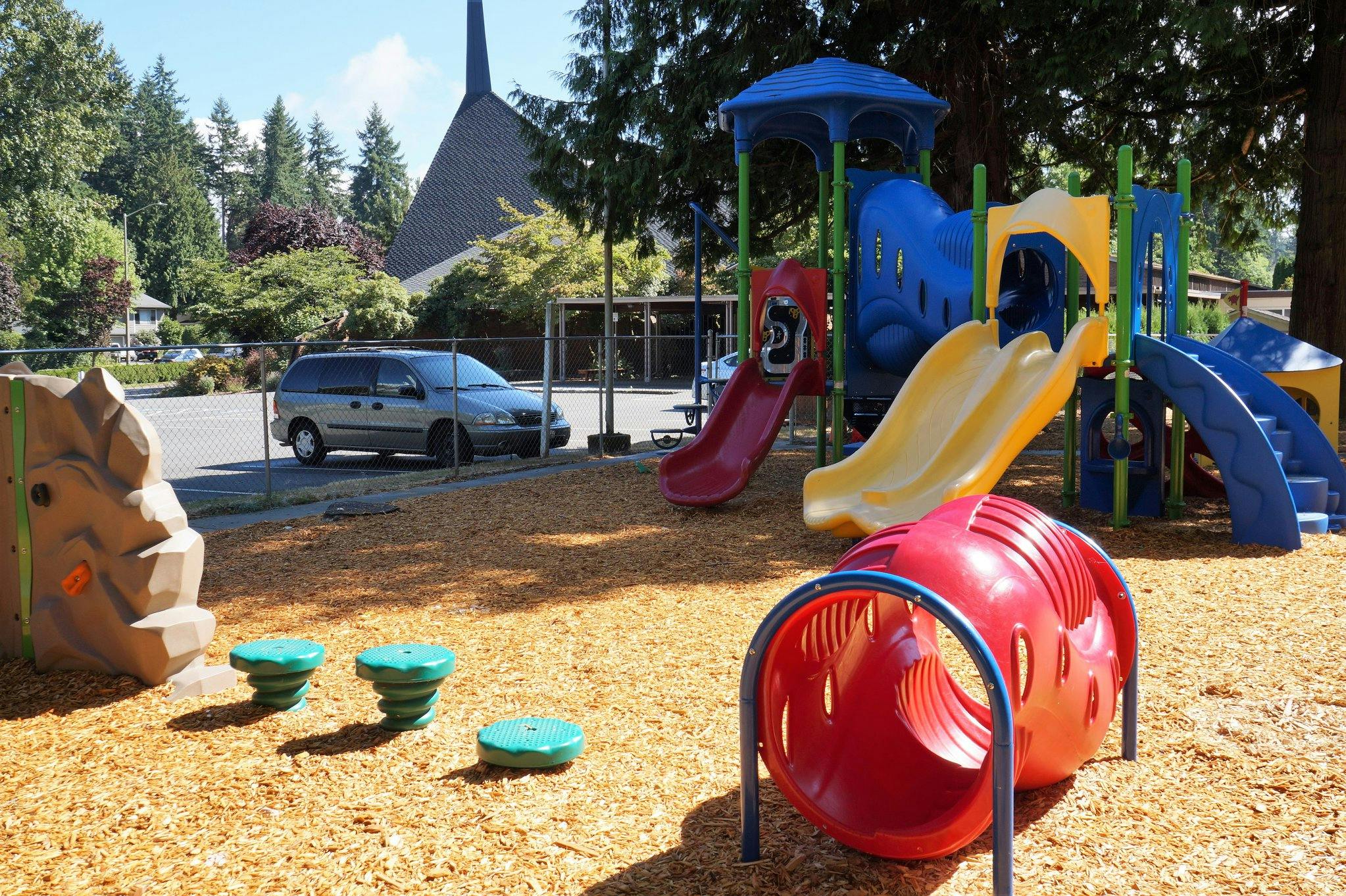 Playground with slides, climbing structures, and a red tunnel
