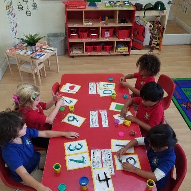 Children at a table playing with number cards