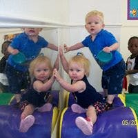 Two children playing with their reflections in a mirror
