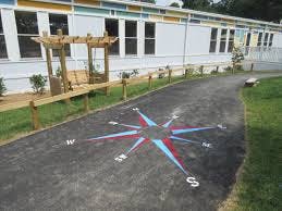 Compass rose painted on a paved path next to a building
