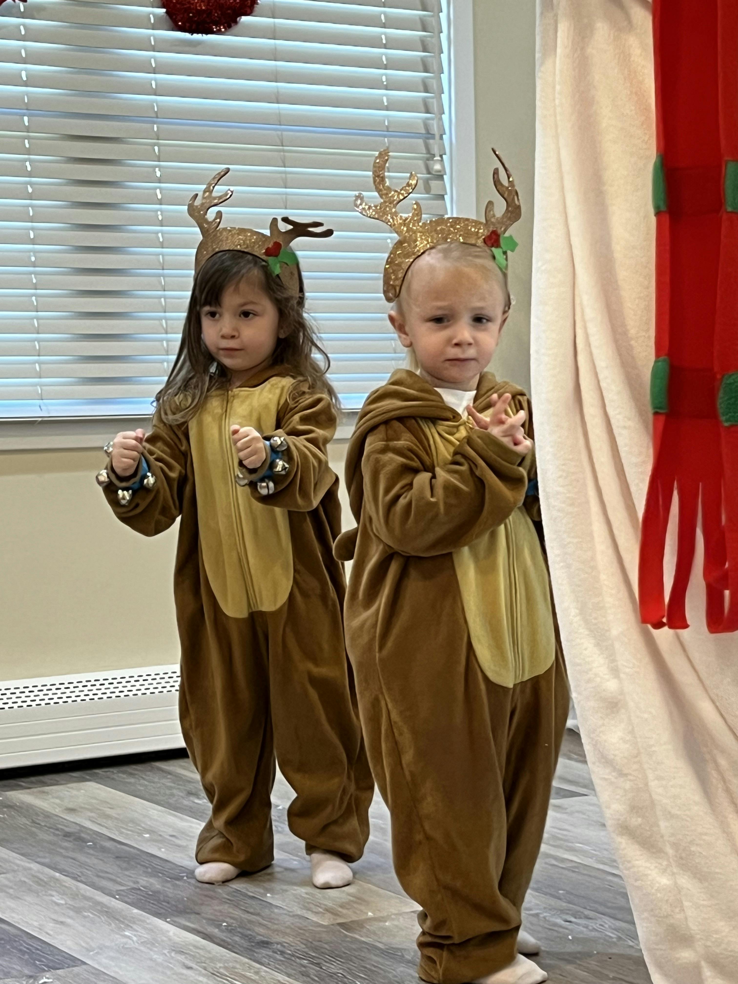 Two children in reindeer costumes with antlers