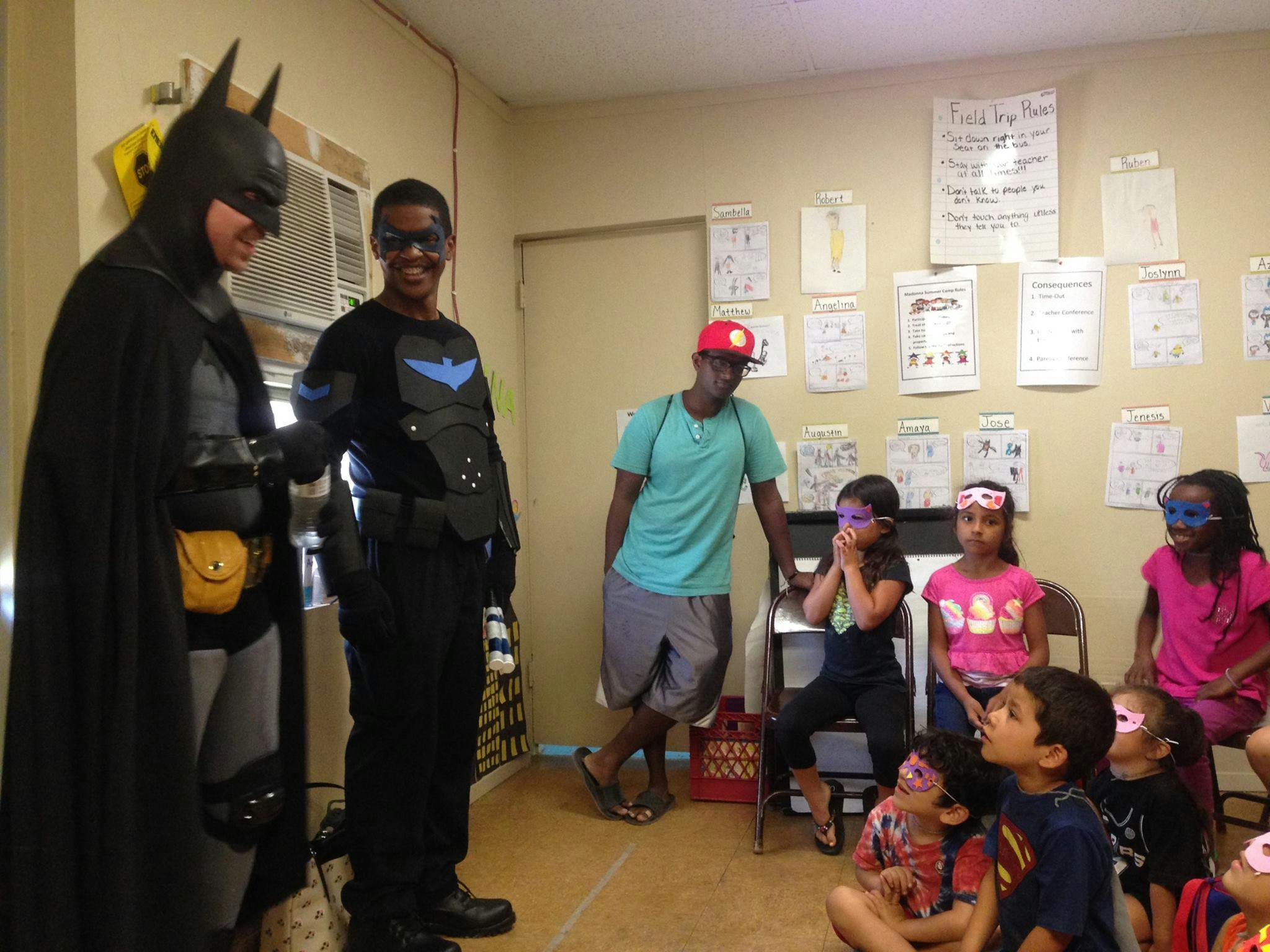 People in superhero costumes with children wearing eye masks