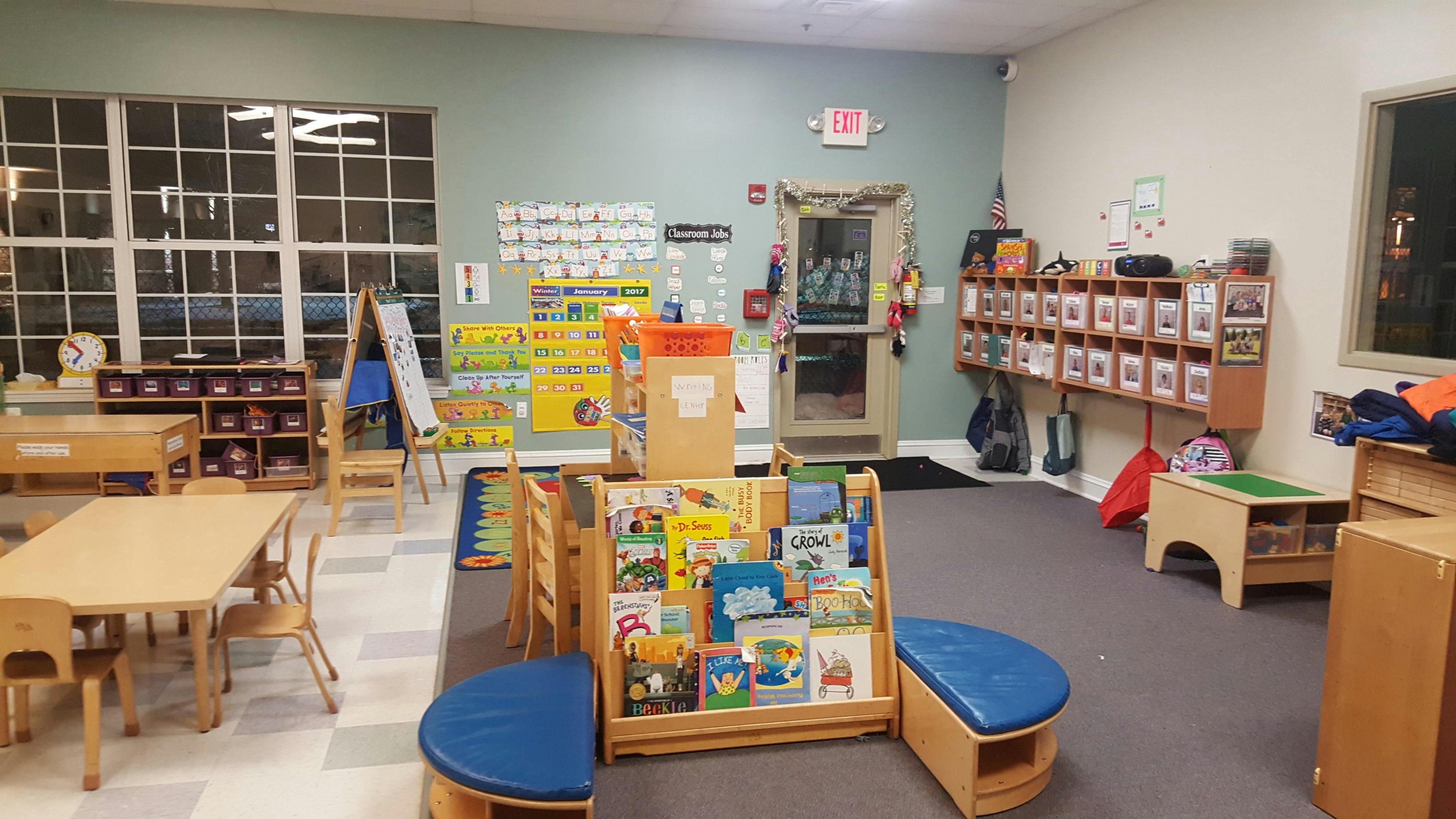 Classroom with tables, chairs, bookshelves, and wall decorations
