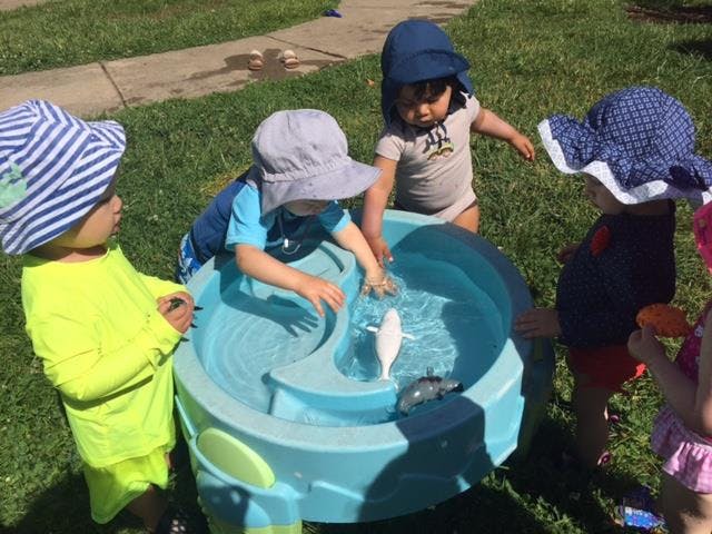 Children playing with a water table outdoors