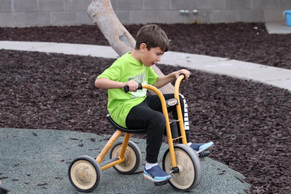 Child riding a tricycle outdoors