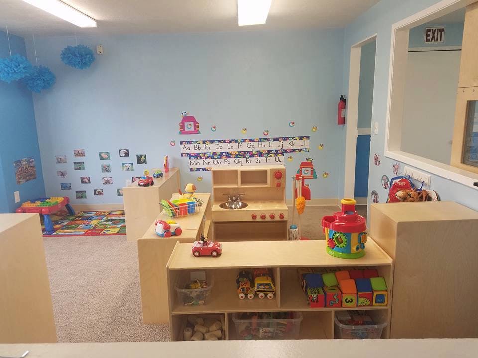 Playroom with toys, play kitchen, and alphabet on the wall