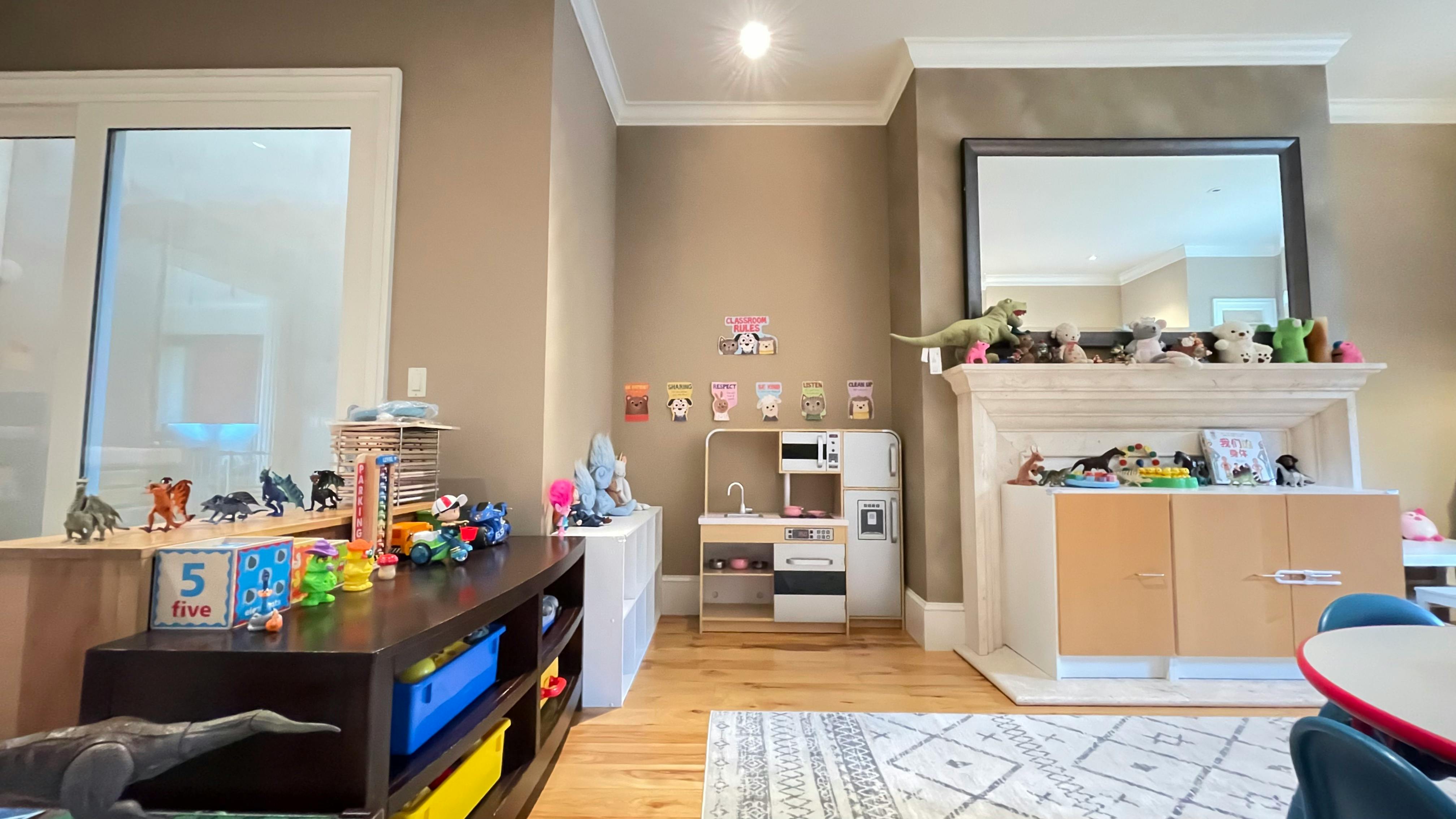 Playroom with toys, play kitchen, and fireplace
