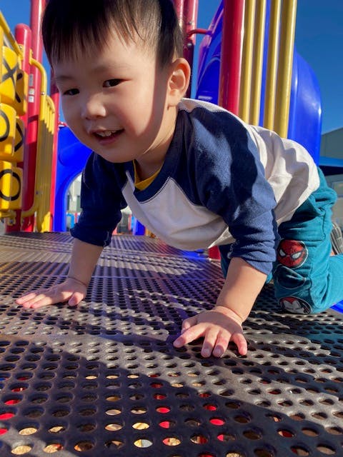 Child crawling on a playground structure