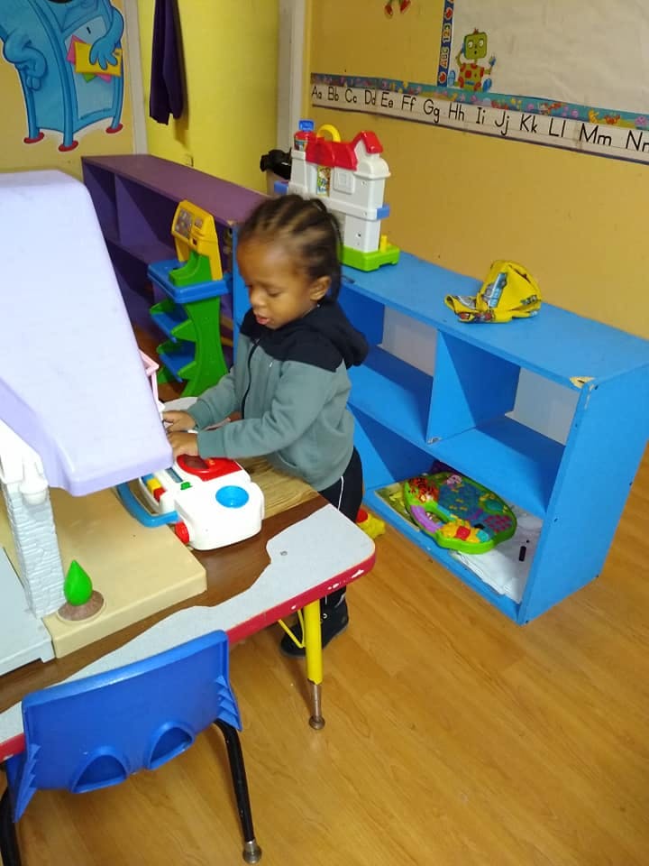 Child playing with a toy in a classroom