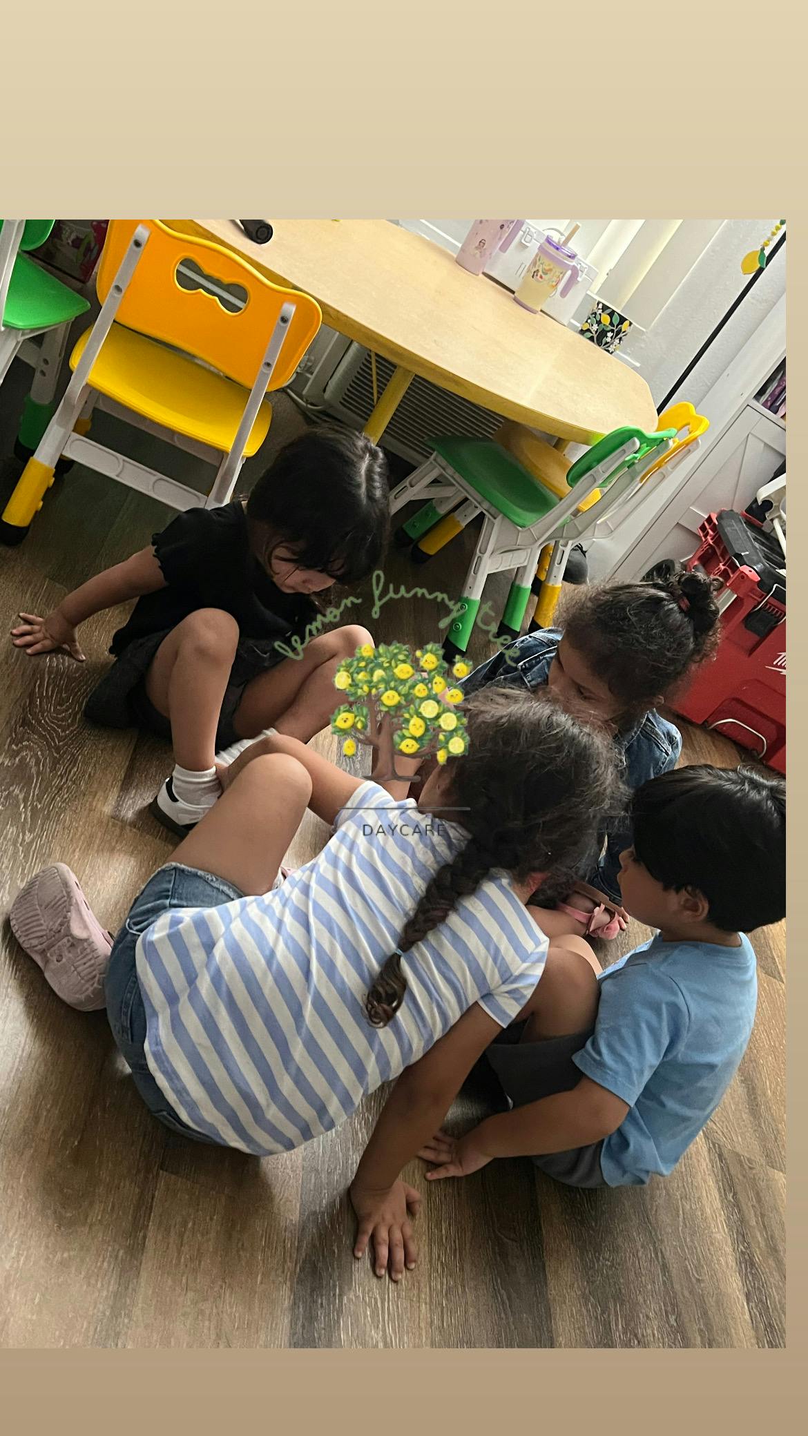 Four children sitting on a wood floor