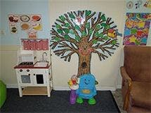 Play kitchen and tree mural in a classroom