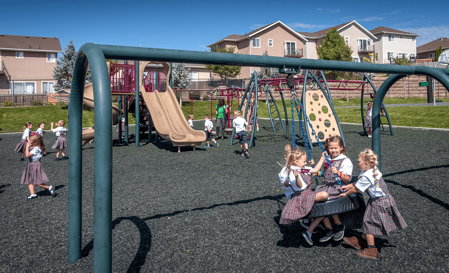 Children playing on a playground with swings and slides