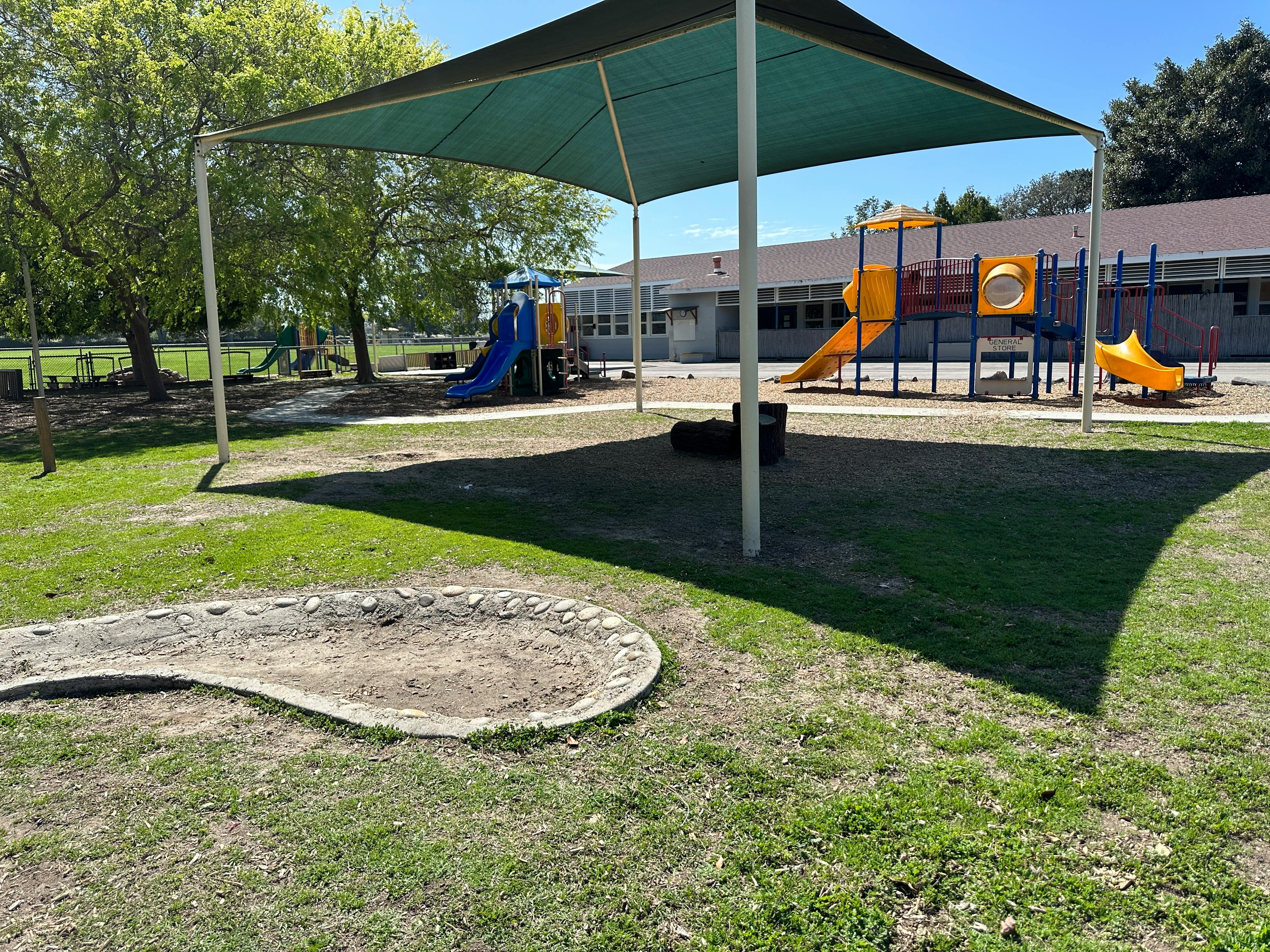 Playground with a shade structure, slides, and climbing equipment