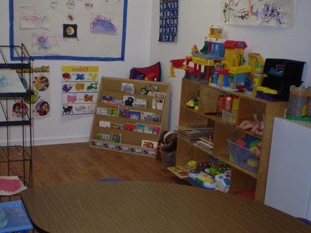 Classroom with toys on shelves and artwork on the wall