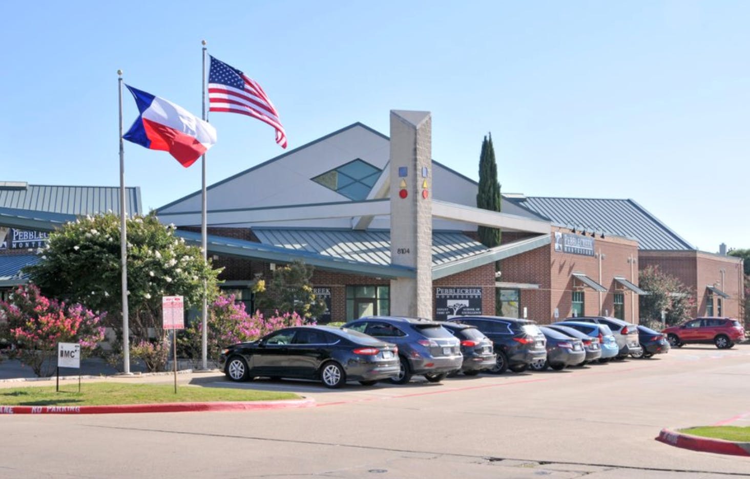 Building with flags and parked cars